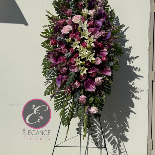 Tall standing floral spray with pink and purple blooms on an easel