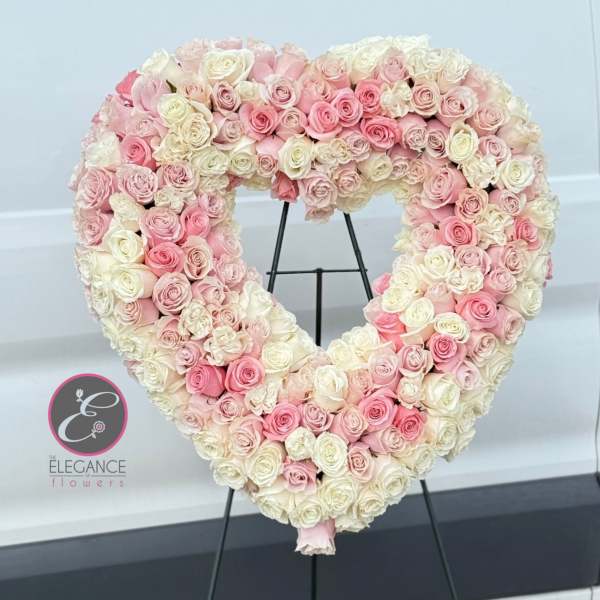 Heart-shaped arrangement of pink and white roses on a stand