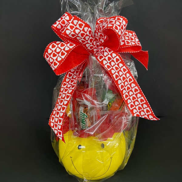 Gift basket wrapped in cellophane with a red heart ribbon and smiley-face container