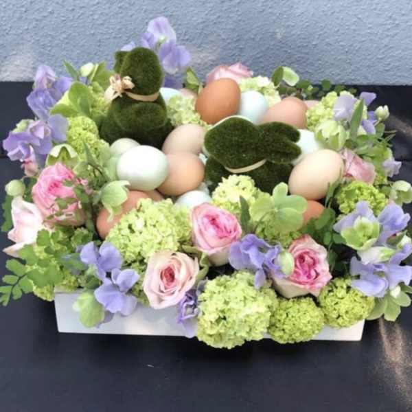 Pastel floral arrangement with eggs and moss bunny figures in a white box