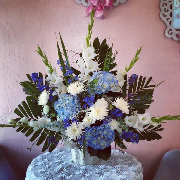 Blue and white floral arrangement in a white vase