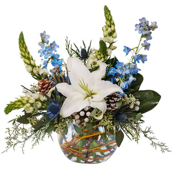 White lily arrangement with blue flowers in a glass vase