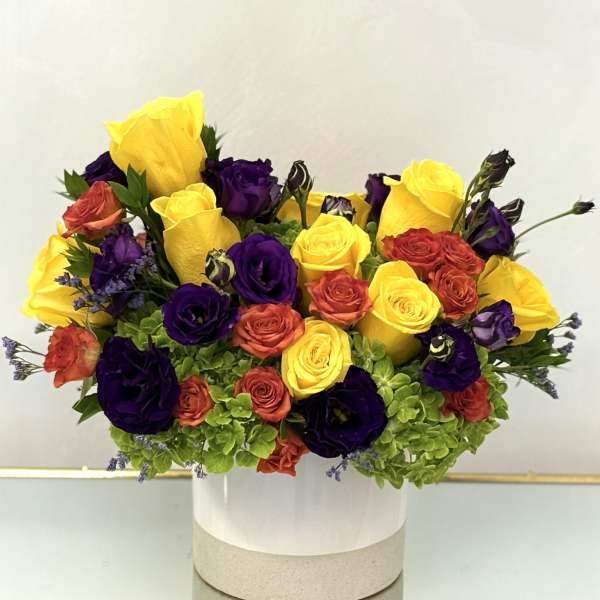 Bouquet of yellow, purple, and coral roses in a white hatbox