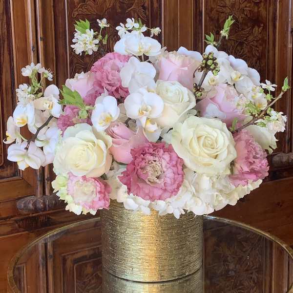 Pink and white floral arrangement in a gold vase
