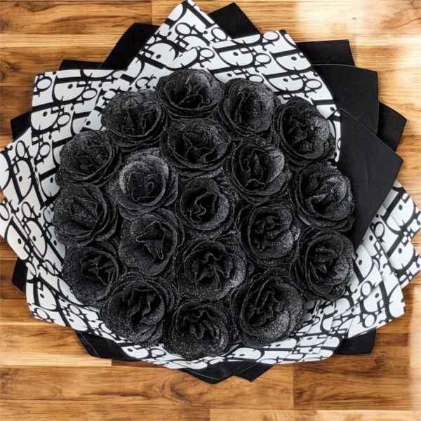 Round bouquet of black glitter roses wrapped in black and white patterned paper