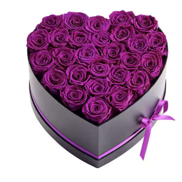 Heart-shaped box filled with purple roses and tied with a ribbon