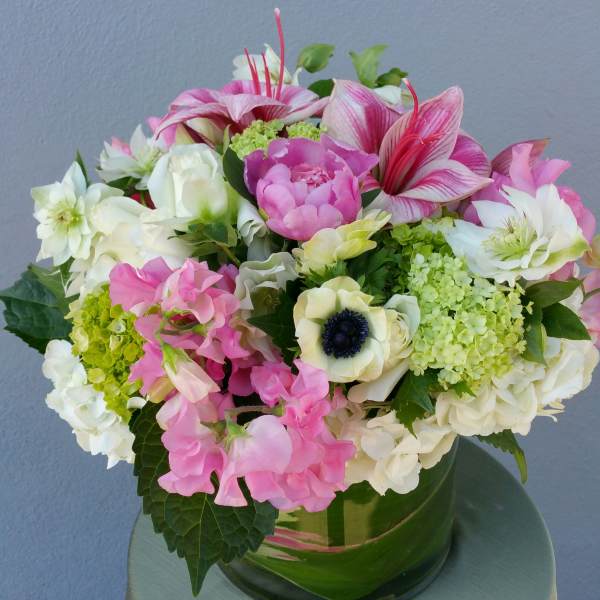 Pink and white mixed bouquet in a green glass vase