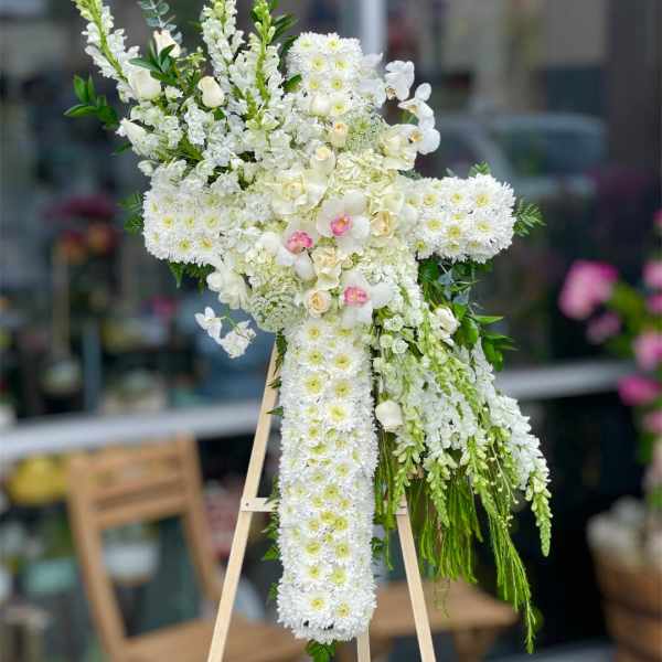 White floral standing spray on an easel with cascading blooms