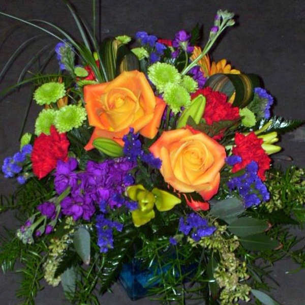 Colorful bouquet with orange roses, purple flowers, and green accents