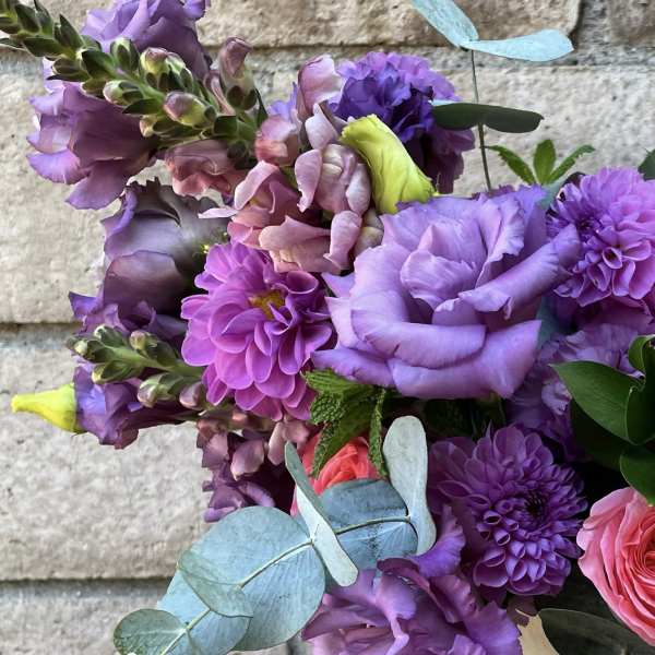 Bouquet of purple and pink flowers with blue eucalyptus leaves