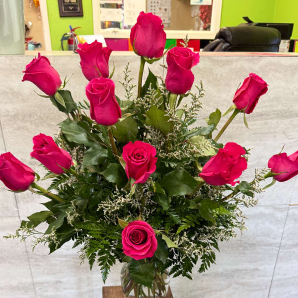 Tall bouquet of hot pink roses in a clear glass vase
