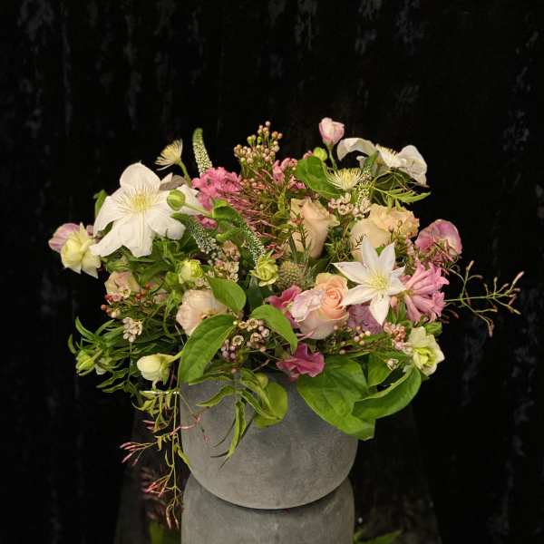 Mixed pink and white floral arrangement in a gray vase