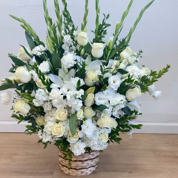 Large white floral arrangement in a woven basket