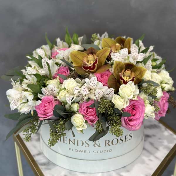 Pink and white roses with orchids in a round hatbox