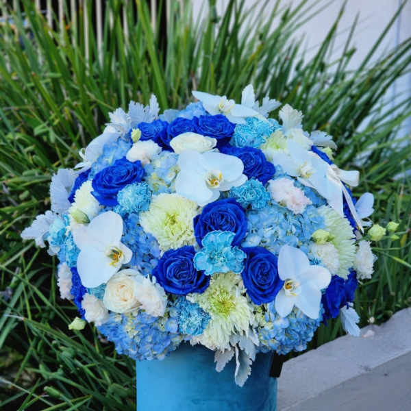 Blue and white floral arrangement in a blue vase