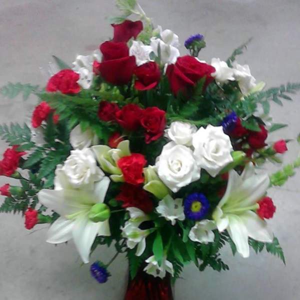 Bouquet of red and white roses with white lilies in a vase
