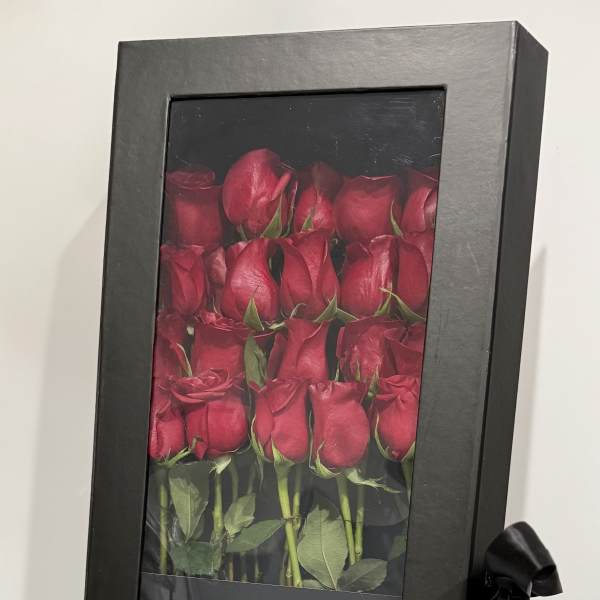 Boxed arrangement of red roses with a black ribbon
