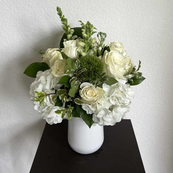 White roses and hydrangeas in a white vase
