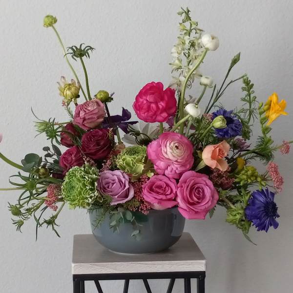 Mixed bouquet of colorful flowers in a gray vase
