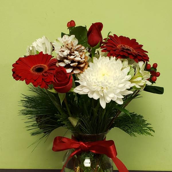 Red and white mixed bouquet in a glass vase with a red ribbon