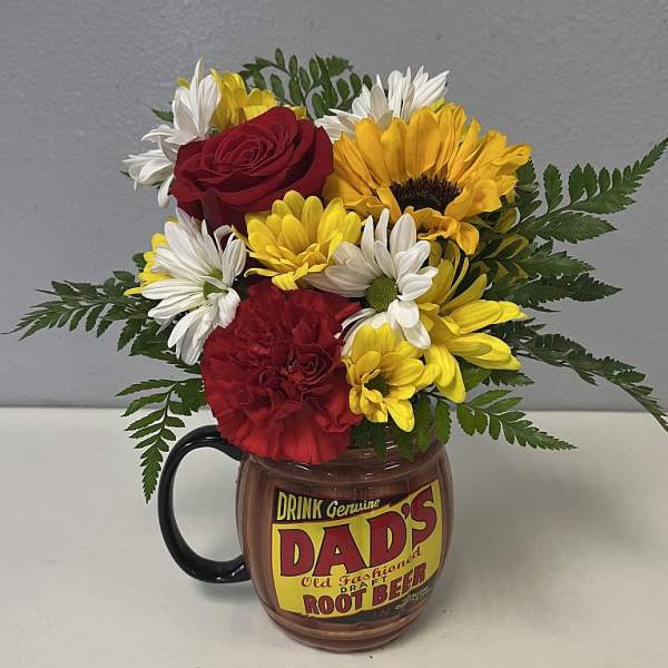 Bouquet of red roses, yellow sunflowers, and white daisies in a mug