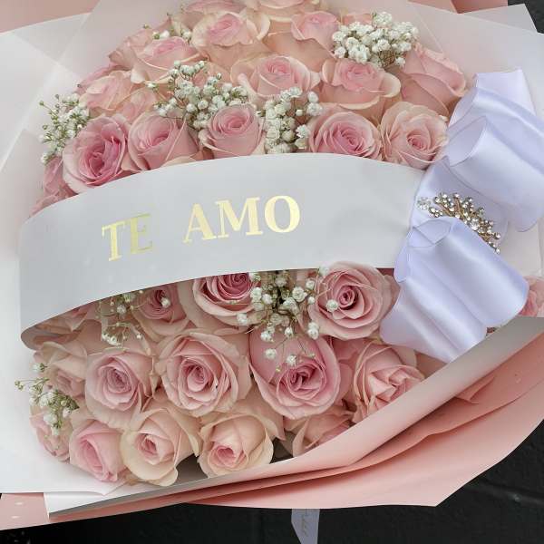 Bouquet of pink roses with baby's breath and a white ribbon