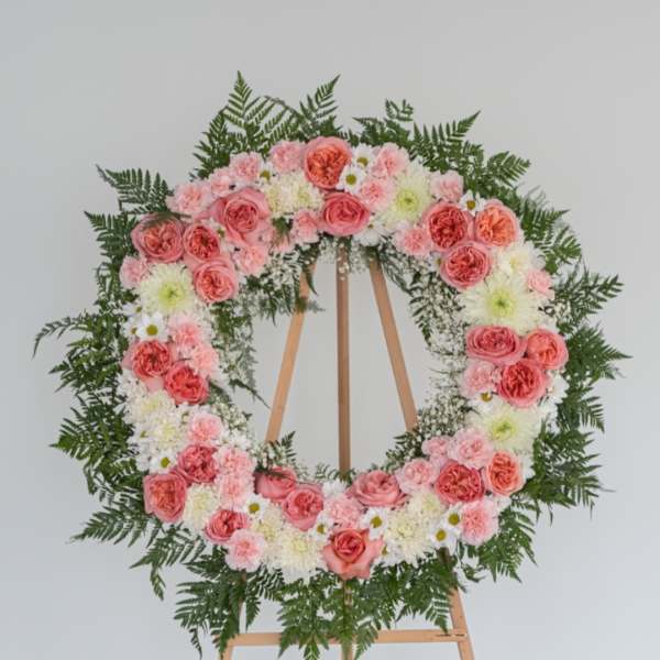 Pink and white floral wreath on a wooden easel