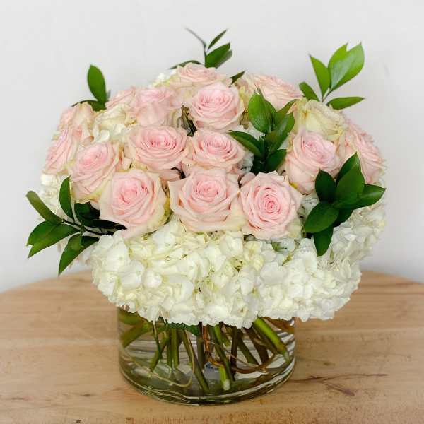 Pink roses and white hydrangeas in a clear glass vase