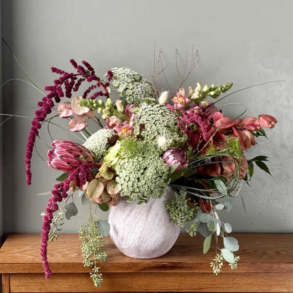 Mixed bouquet in a white vase with pink and white blooms