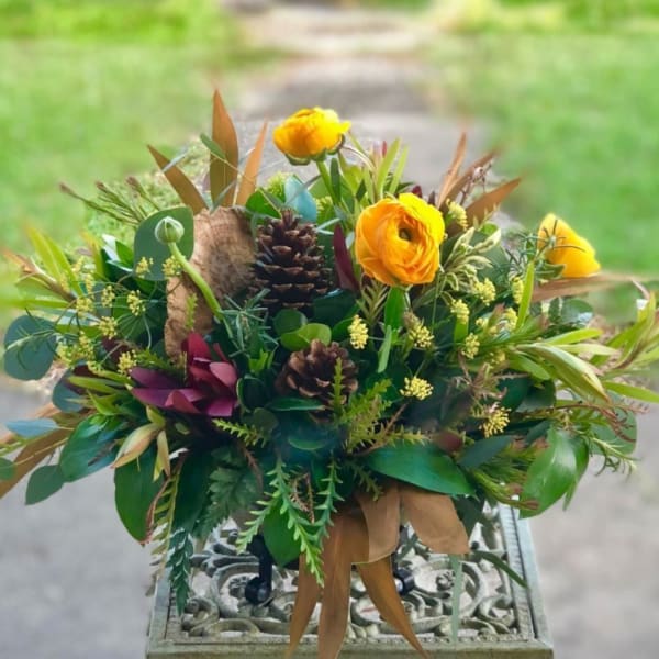 Bouquet of yellow flowers with pinecones and mixed foliage