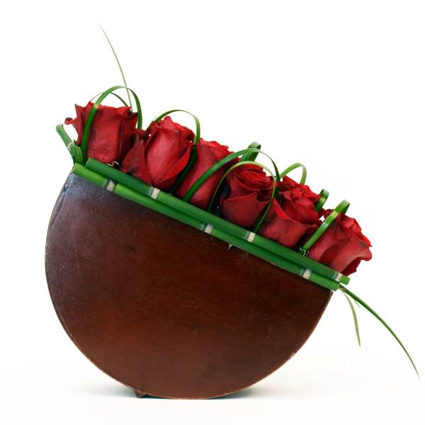 Red roses arranged in a curved brown container
