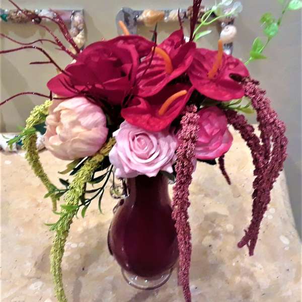 Bouquet of magenta and pink flowers in a dark vase