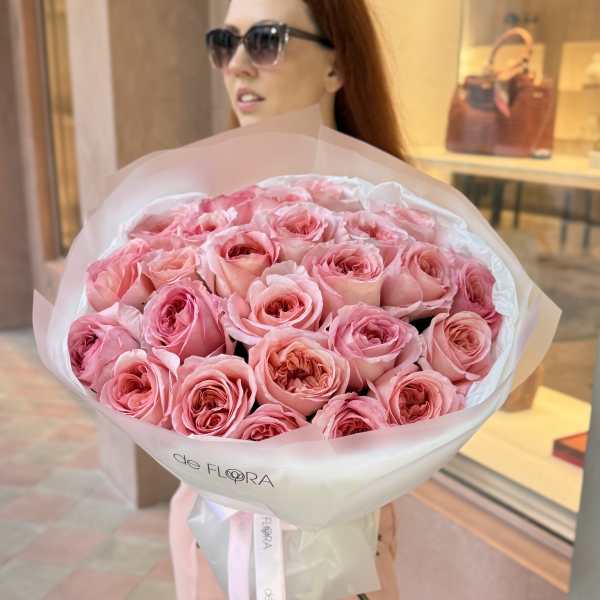 Large bouquet of pink roses wrapped in white paper with a ribbon