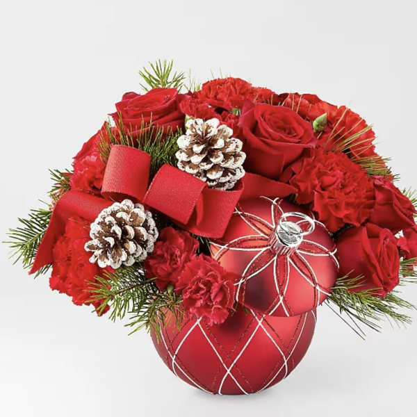 Red roses and carnations arranged with pinecones in a red ornament vase
