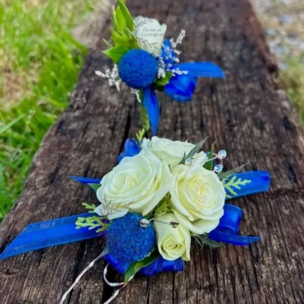 White rose corsage and matching boutonniere with bright blue ribbon accents