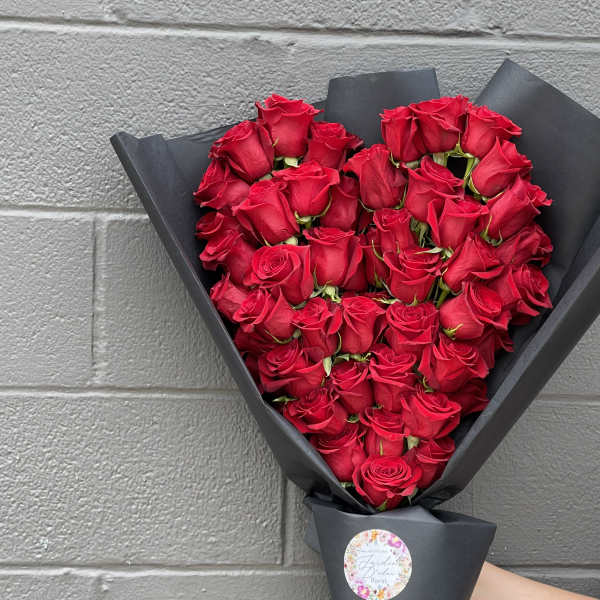 Bouquet of red roses wrapped in black paper