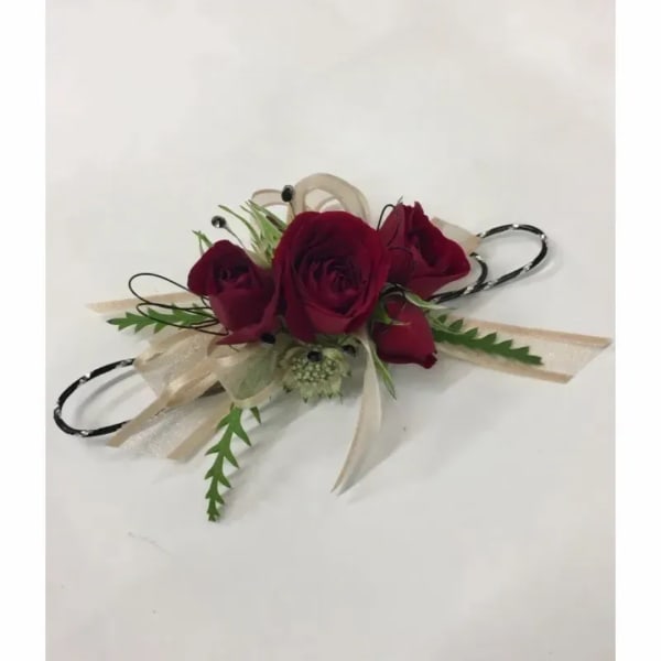 Corsage with burgundy roses and beige ribbon on a white background