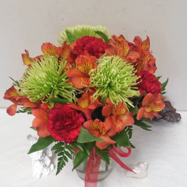 Bouquet of orange alstroemeria and red carnations in a glass vase