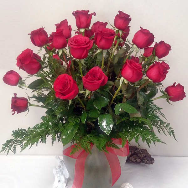 Bouquet of red roses in a frosted glass vase with a pink ribbon