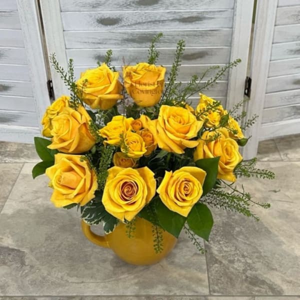 Yellow roses arranged in a yellow mug-style vase