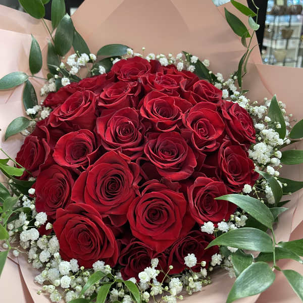 Bouquet of red roses with white baby's breath and green foliage