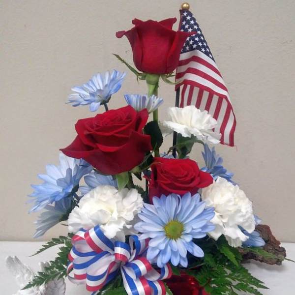 Red roses and blue-white daisies arranged with an American flag