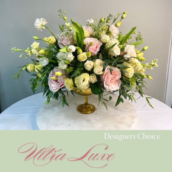 Pastel rose and lisianthus arrangement in a gold pedestal vase