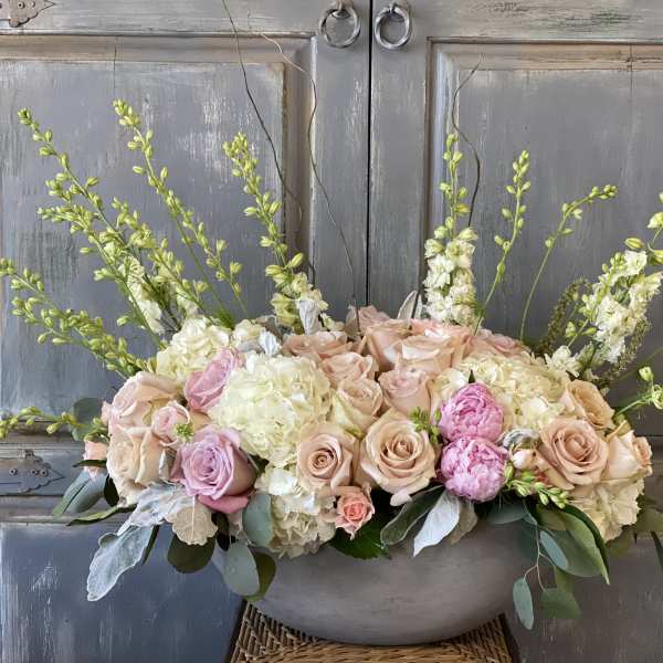 Pastel floral arrangement in a gray bowl with roses and tall white spikes