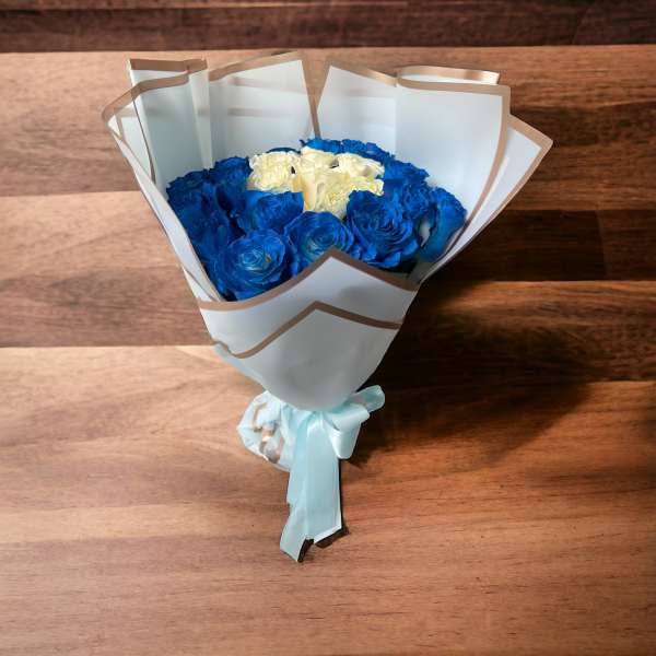 Bouquet of blue and white roses wrapped in white paper with a ribbon