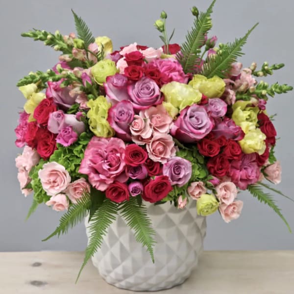 Mixed pink and red roses in a white textured vase