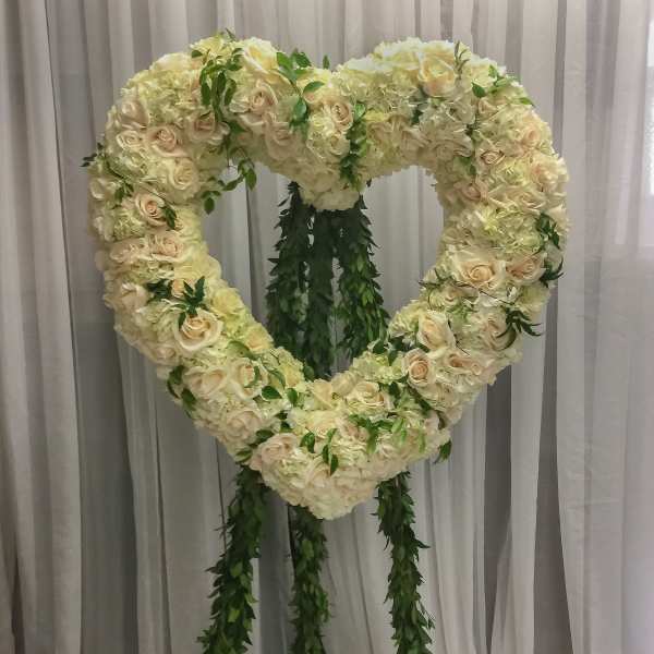 Heart-shaped floral standing arrangement with cream roses and hydrangeas