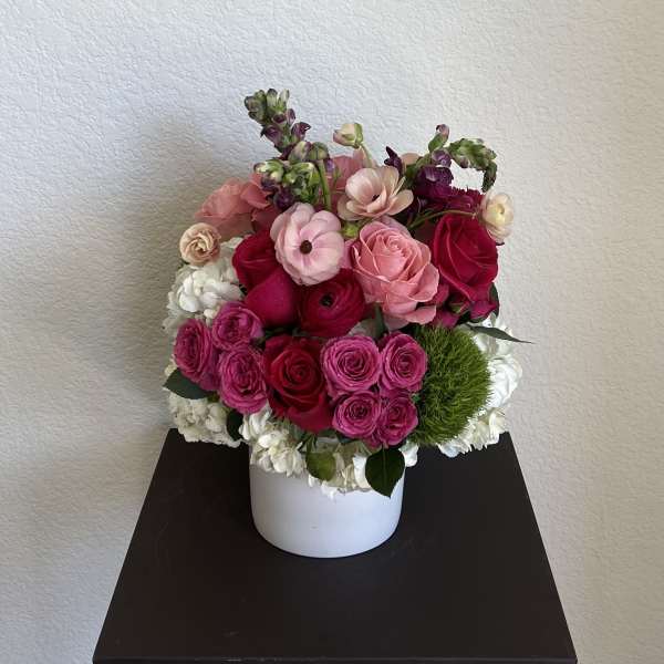 Pink and red flower arrangement in a white vase