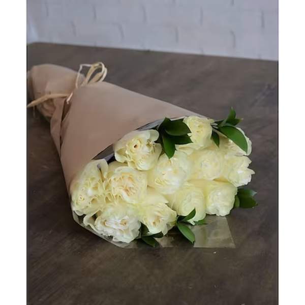 Bouquet of cream-colored roses wrapped in tan paper