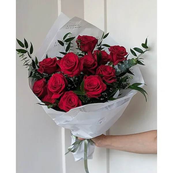 Bouquet of red roses wrapped in white paper